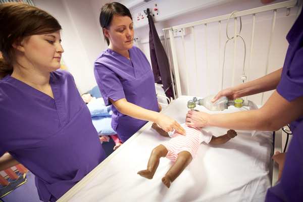 Student nurses practicing CPR on baby resuscitation manikins