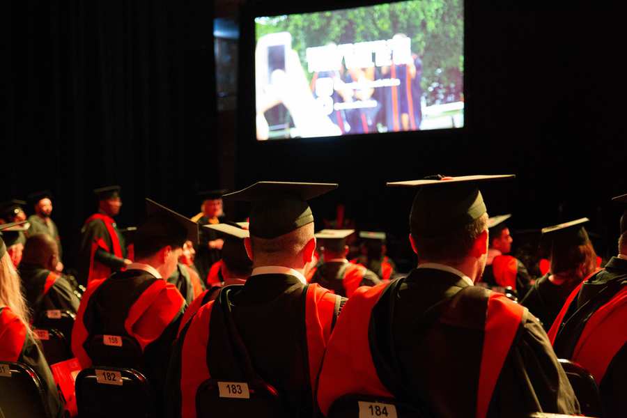 Graduation hats looking towards a screen